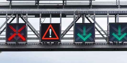 Schilderbrücke mit elektronischer Fahrspuranzeige. Composing Fotolia / Adobe Stock 175263711 & 175263486 (Zatevakhin: Digital road signs – pointer lane)
